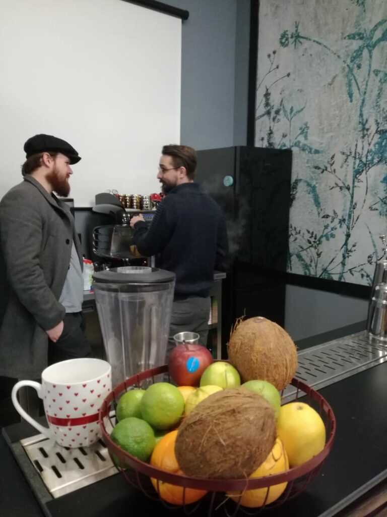 Kursant i instruktror stoją przy ekspresie do kawy